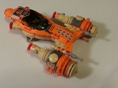 an orange and black toy vehicle on a white surface