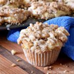 a muffin is sitting on a wooden table next to a blue towel and some other food