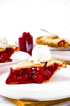 a piece of pie on a plate with whipped cream and raspberry sauce in the background