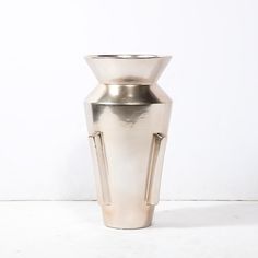 a silver vase sitting on top of a white table