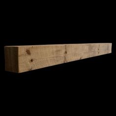 a close up of a wooden shelf against a black background