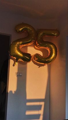 the number twenty five balloons are hanging on the wall