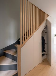 an open closet under the stairs in a house