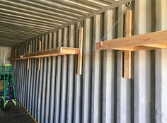 some wooden planks are hanging from the side of a metal wall with chains attached to them