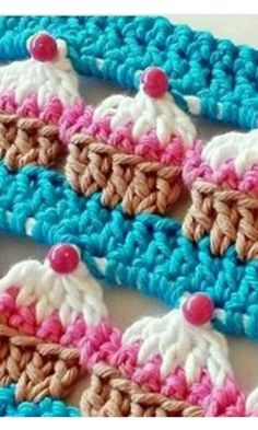 two crocheted pieces with pink, white and blue trims on top of each other