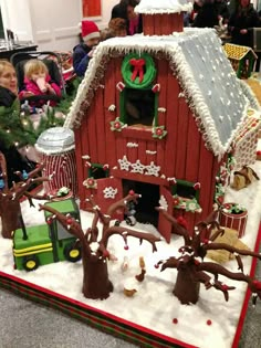 a red barn with christmas decorations and people around it