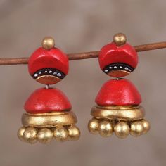 By Deepti Lav, these parasol shaped Indian jhumki earrings dazzle a room. The bases are first molded from double-fired terracotta clay. The artist hand-paints the fired ceramic pieces in hues of gold and red before mounting them on sterling silver posts. Indian Ceramics, Traditional Indian Jewellery, Clay Diy Projects, Terracotta Jewellery, Terracotta Clay, Ceramic Pieces, Jhumki Earrings, Gold And Red, Diy Clay