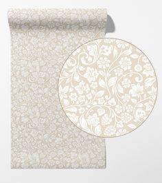 a white and beige wallpaper with an ornate design on the front, along with a round plate