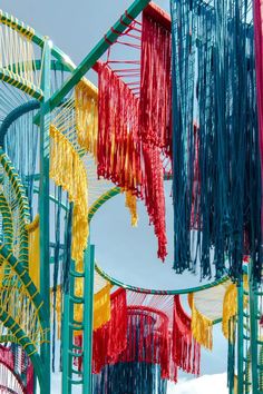 many different colored objects are hanging in the air with strings attached to them and some snow on the ground