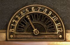 an old fashioned clock with roman numerals on the face and numbers below it