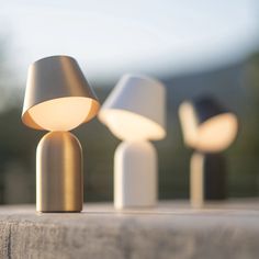 three lamps sitting on top of a wooden table