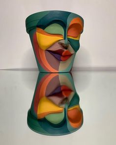 a colorful vase sitting on top of a glass table