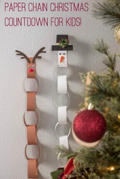 paper chains are hanging on the wall next to a christmas ornament and snowman