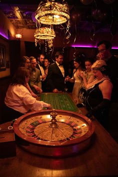 a group of people standing around a table with a rouleet in front of them