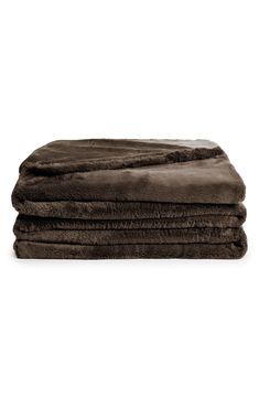 three blankets folded on top of each other in dark brown color, with one blanket folded over the edge