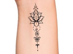 a black and white tattoo design on the side of a woman's leg with a flower