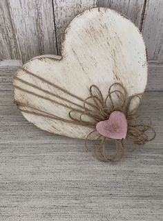 a heart shaped wooden object with a ring on it