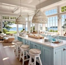 a kitchen filled with lots of counter top space next to an open floor plan and large windows