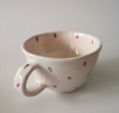 a white coffee cup with strawberries on it