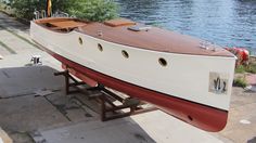 a boat sitting on top of a wooden platform next to the water in front of a building