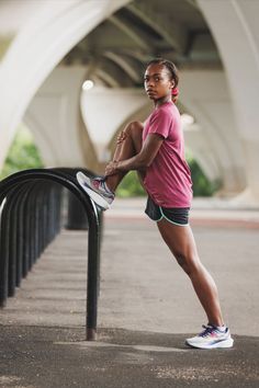 a woman leaning against a rail with her foot on the railing