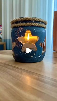 a blue jar with a lit candle in it