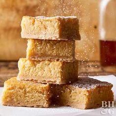 three pieces of cake sitting on top of a white napkin next to a jar of syrup