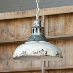 an old metal light hanging from a wooden wall