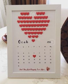 a calendar with hearts in the shape of a heart is displayed on a table next to some chocolates