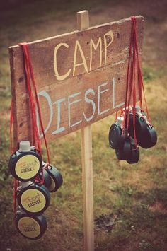 a sign that says camp diesel hanging from the side of a field with some boxing gloves attached to it