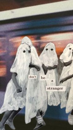 three people in ghost costumes walking down the street with words written on their faces and hands