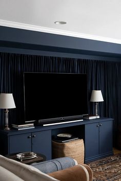 a flat screen tv sitting on top of a blue entertainment center in a living room