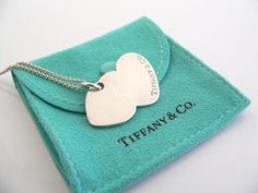 Overview:Offered for sale is a wonderful Tiffany classic.   Whether you are just starting your Tiffany collection or are thinking of adding another piece, this one is perfect for you.  Tiffany & Co.'s Sterling Silver Double Hearts necklace is a Tiffany classic that will never go out of style. It will most certainly be a piece that you will turn to over and over again, so it is great value for your money!  It is a wonderful necklace that fits a lifestyle on the go -- the necklace can be wor Double Heart Tiffany, Tiffany And Co Necklace, Double Heart Necklace, Hearts Necklace, Tiffany Style, Tiffany And Co, Double Heart, Gift Pouch, Tiffany Blue