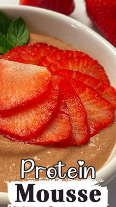 a close up of a bowl of food with strawberries on top and the words protein mousse above it