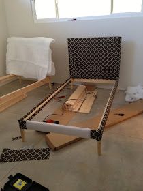 a bed frame is being built in the middle of a room with tools on the floor