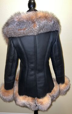 Our gorgeous high low shearling is in black with stunning crystal fox fur. This coat has a zip closure and two pockets. This shearling runs true to size. Black Leather Fur Coat With Faux Fur Trim, Elegant Black Sheepskin Fur Coat, Fitted Black Sheepskin Fur Coat, Luxury Black Sheepskin Fur Coat, Black Sheepskin Fur Coat With Faux Fur Lining, Fitted Shearling Fur Coat With Faux Fur Lining, Luxury Black Fur Coat With Feather Trim, Luxury Shearling Fur Coat With Faux Fur Trim, Fitted Black Fur Coat With Faux Fur Trim