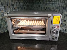 a toaster oven sitting on top of a counter next to a glass tile backsplash