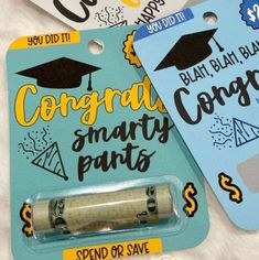 two graduation tags, one with a lighter and the other with money