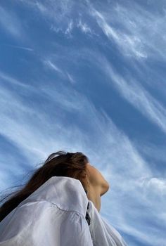 a woman with long hair is looking up into the sky