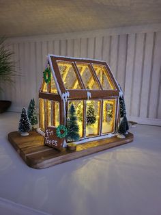 a lit up christmas house with trees on the outside and lights in the front window