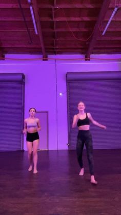 two young women are dancing in a dance studio