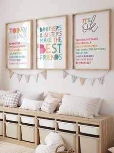 three framed pictures hang on the wall above a bench with storage bins underneath it