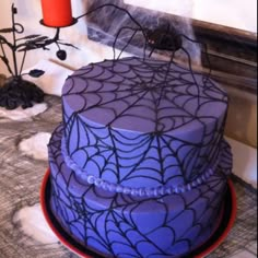 there is a purple cake with spider web on it