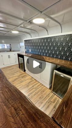 the inside of an airplane with wood flooring and white cupboards on each side