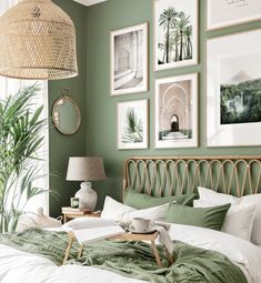 a bedroom with green walls and pictures on the wall above the bed, along with a wicker headboard