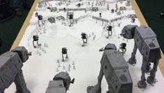 a long table topped with lots of toy figurines sitting on top of snow covered ground