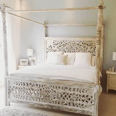 a white bed sitting in a bedroom on top of a floor next to a window