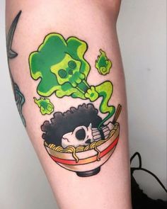 a person with a tattoo on their leg has a bowl of noodles in front of them