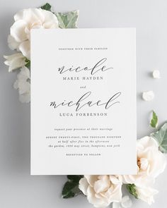 a wedding card with flowers and greenery