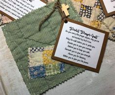 a cross and some cards on top of a quilted table cloth with words written in it